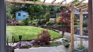 a garden with a pergola and a yard with flowers at Hetherington House in Maybole