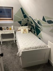 a bedroom with a bed with a geometric wall at Hetherington House in Maybole