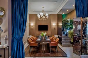 a dining room with blue curtains and a table and chairs at Chekhoff Hotel Moscow Curio Collection By Hilton in Moscow