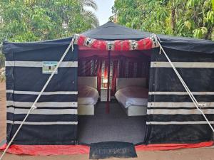 a black tent with two beds in it at Mango Farm Camp in Al-Disah