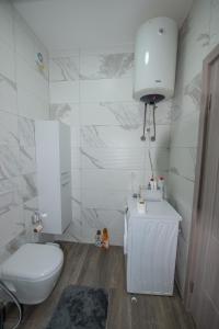 a white bathroom with a toilet and a sink at Apartment Lara in Ulcinj