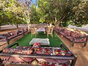 a group of couches sitting on the grass with a table at Mango Farm Camp in Al-Disah