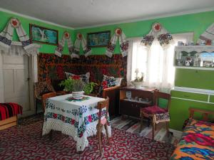 una sala de estar con mesa y una habitación con paredes verdes en PENSIUNEA ROMINVEST, en Borşa