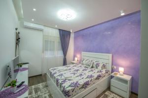 a purple bedroom with a bed and two night stands at Apartment Lara in Ulcinj