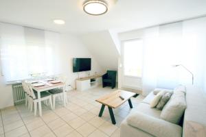 sala de estar con sofá y mesa en Ferienwohnung Muschelweg 9b Ostermann, en Norddeich