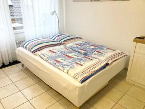 Una cama con edredón en un dormitorio en Ferienwohnung Muschelweg 9b Ostermann, en Norddeich