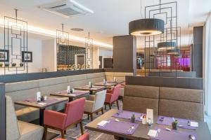 a restaurant with tables and chairs and a bar at Hilton Garden Inn Munich City West in Munich