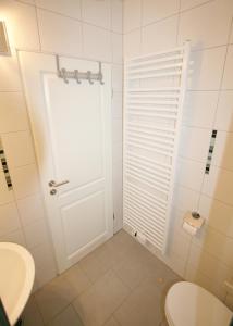baño con puerta blanca y aseo en Ferienwohnung Muschelweg 9b Ostermann, en Norddeich
