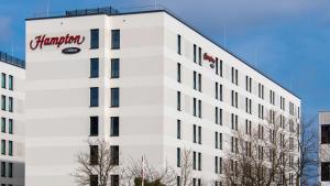 a white building with a pharmacy sign on it at Hampton By Hilton Munich City North in Munich