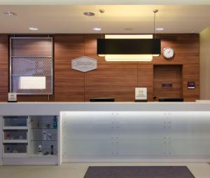 a reception counter in a dental office with a clock at Hampton by Hilton Nürnberg City Center in Nürnberg