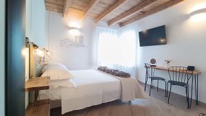 a bedroom with a bed and a desk and a table at Casa Cuccagna Chioggia - Vista Canal Vena in Chioggia
