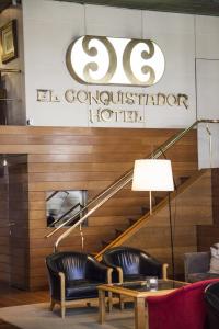 a lobby with a hotel sign and chairs and a table at El Conquistador Hotel in Buenos Aires