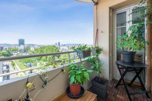 a balcony with potted plants and a stool at Beautiful 2-room apartment with a view in Lyon - Welkeys in Lyon