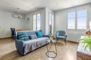 a living room with a blue couch and a chair at Beautiful 2-room apartment with a view in Lyon - Welkeys in Lyon