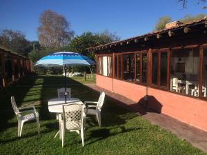 einen Tisch und Stühle mit Sonnenschirm im Hof in der Unterkunft La Casa de Reyes Posada in Reyes