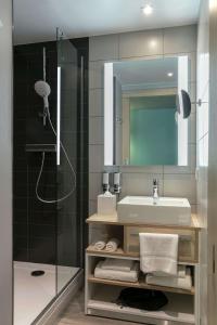 a bathroom with a sink and a shower at Hampton By Hilton Paris Clichy in Clichy