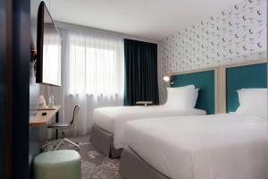 克利希的住宿－Hampton By Hilton Paris Clichy，酒店客房配有两张床和一张书桌