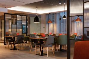 une salle à manger avec des tables et des chaises dans l'établissement Hilton Garden Inn Paris Orly Airport, à Rungis