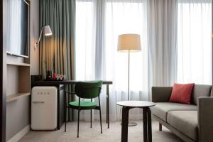 un soggiorno con divano, tavolo e sedie di Hilton Garden Inn Paris Orly Airport a Rungis