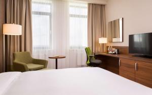 オレンブルクにあるHilton Garden Inn Orenburgのベッド1台、薄型テレビが備わるホテルルームです。