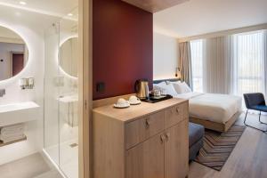 a hotel room with a bed and a bathroom at Hampton by Hilton Riga Airport in Rīga