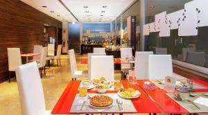 een eetkamer met een tafel met eten erop bij Hilton Garden Inn Rome Claridge in Rome