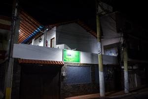 znak na boku budynku w nocy w obiekcie RECANTO PRAIA SUITES w mieście Arraial do Cabo