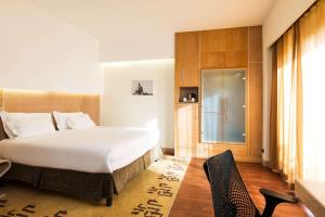 a bedroom with a large white bed and a window at Hilton Garden Inn Rome Claridge in Rome