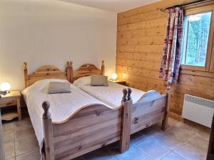 a bedroom with two beds and a window at Lucada Les Carroz in Les Carroz d'Araches