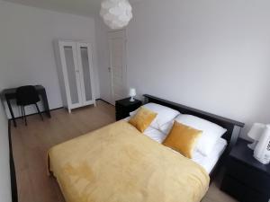 Un dormitorio con una cama con una manta amarilla. en Alicja apartament, en Siemianowice Śląskie