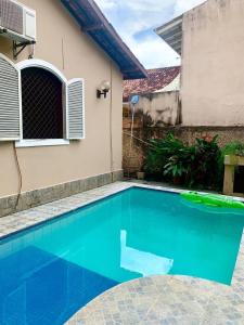 a swimming pool in front of a house at Retiro Luxuoso:Casa Espaçosa com Piscina Privativa in Campos dos Goytacazes