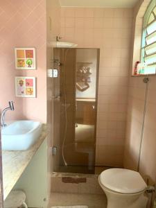 uma casa de banho com um chuveiro, um WC e um lavatório. em Retiro Luxuoso:Casa Espaçosa com Piscina Privativa em Campos dos Goytacazes