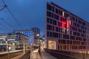 a building with a red sign on the side of it at Hampton by Hilton Stuttgart City Centre in Stuttgart