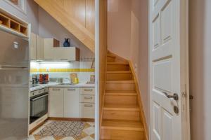 a small kitchen with white cabinets and a staircase at Koletti 7 in Nafplio