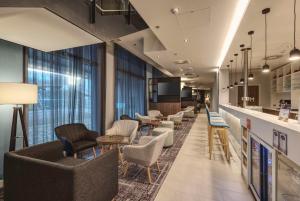 a lobby with chairs and tables and a bar at Hampton by Hilton Stuttgart City Centre in Stuttgart