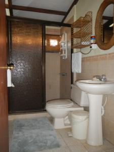 a bathroom with a toilet and a sink at Punta Roca Surf Resort in La Libertad