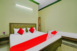 a bedroom with a large bed with red pillows at Flagship B N Palace in Raipur