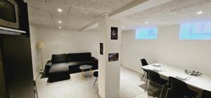 ein Wohnzimmer mit einem schwarzen Sofa und einem Tisch in der Unterkunft New York basement apartment in Kopenhagen