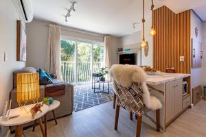 a living room with a kitchen and a living room with a couch at Bem localizado - @stayhousetemporada in Canela
