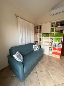 ein blaues Sofa im Wohnzimmer mit Bücherregalen in der Unterkunft B&B Easy Wind in Cala Gonone