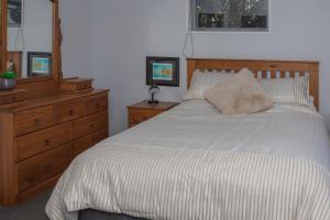 1 dormitorio con 1 cama con tocador de madera y 1 cama sidx sidx sidx sidx en Colcord Hideaway en Methven