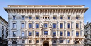 DoubleTree By Hilton Trieste في ترييستي: مبنى أبيض كبير مع الكثير من النوافذ