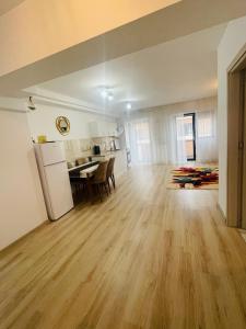 una sala de estar vacía y una cocina con suelo de madera. en Apartament YRA Rm.Valcea en Râmnicu Vâlcea