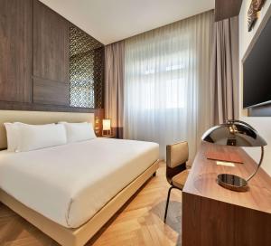 Een bed of bedden in een kamer bij DoubleTree By Hilton Trieste