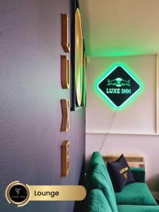 a room with a green couch and a sign on the wall at Bull's Ring 3Bed Penthouse City Centre in Birmingham