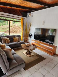 sala de estar con sofá, TV y mesa en Appartements au cœur de Maharepa, en Maharepa