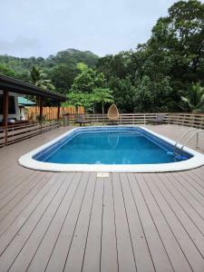 a swimming pool on a deck with a wooden floor at Appartements au cœur de Maharepa in Maharepa