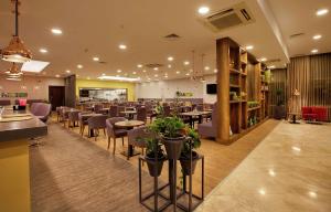 a restaurant with tables and chairs in a room at Hilton Garden Inn Kocaeli Sekerpinar in Şekerpınarı