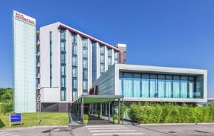 a large white building with glass windows at Hilton Garden Inn Venice Mestre in Mestre