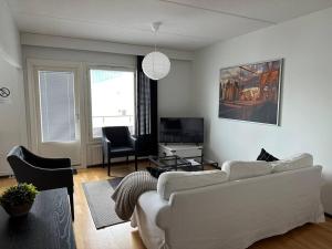 a living room with a white couch and a tv at Tornio Sauna appartment 2BR in Tornio
